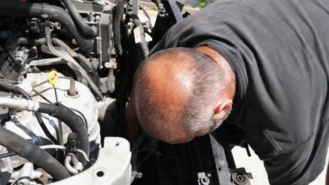 Repairer making maintenance of car at workplace. Adult auto mechanic working Stock Footage 304425784
