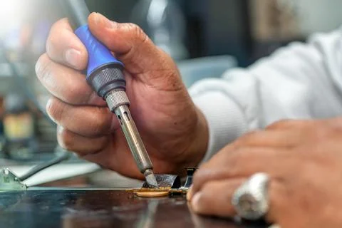 Repairing computer connector in electronics lab with precision tools close-up 写真素材