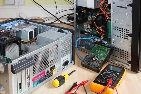 Repairing computers. Open tower PC with multimeter Stock Photos