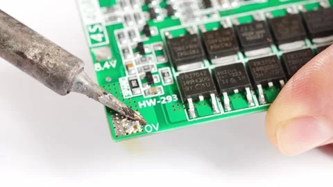Repairing electronics on a circuit board with soldering tools Stock Footage 333246351