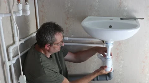 Repairing leak under wash basin in bathr... | Stock Video | Pond5