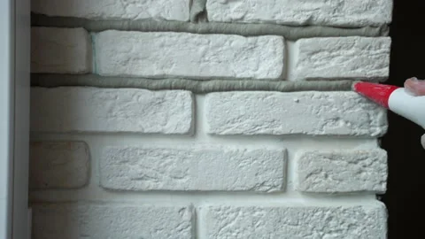 Repairing process of interior wall with white decorative stones, builder Stockbeeldmateriaal 208856600