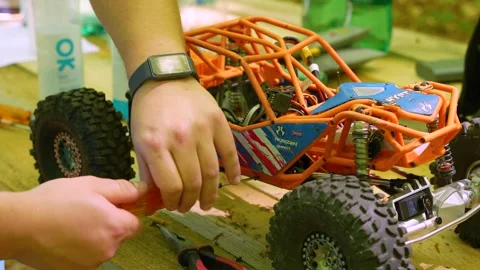 Repairing remote controlled RC off-road car in pit stop Stock Footage 336435977