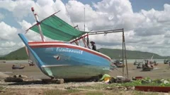 Traditional Thai wooden commercial fishing boat undergoing repair