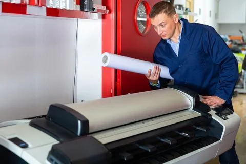Repairman changes paper roll in plotter Foto stock