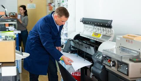 Repairman changes paper roll in plotter Foto stock