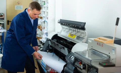 Repairman changes paper roll in plotter Foto stock