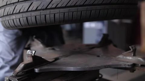 Repairman clamp wheel disk in fitting machine to remove rubber tire. Video stock 262546461
