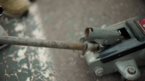 Repairman completed work with the machine and removes the hydraulic rolling jack 스톡 동영상 128492893