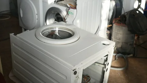 A repairman is completely dismantling a control panel on the washing machine. He Stock Footage 87549927