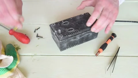 The repairman disassembles and repairs the old charger. Stock Footage 151136557