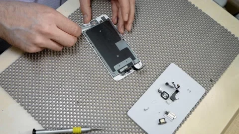 A repairman disassembles a smartphone for parts using special tools Stock Footage 137689432