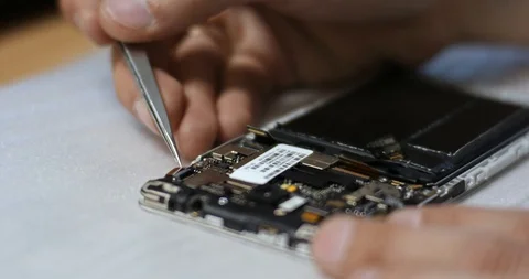 Repairman disassembling smartphone with screwdriver. Technician fixing broken Stock Footage 102383583