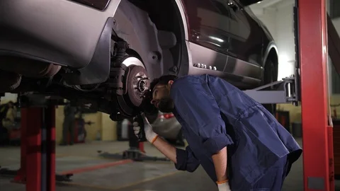 Repairman with flashlight checking car chassis Stock Footage 123507122