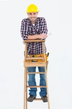 Repairman holding spanner while climbing ladder Stock Photos