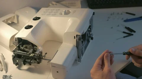 Repairman master is collecting and testing sewing machine after repairing. Stock Footage 136906522