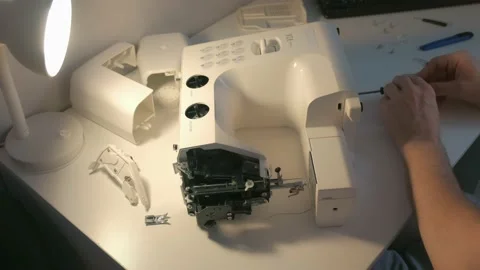 Repairman master is collecting and testing sewing machine after repairing. Stock Footage 136906533