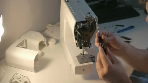 Repairman master is collecting and testing sewing machine after repairing. Video stock 137694075