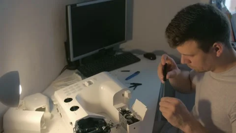 Repairman master is collecting and testing sewing machine after repairing. Stock Footage 137782650