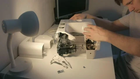 Repairman master is collecting and testing sewing machine after repairing. Stock Footage 137889072