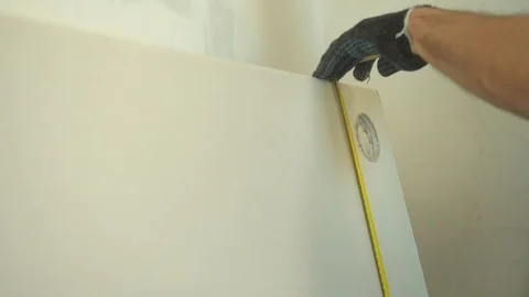 Repairman measures a length of the wall Stock Footage 124842640