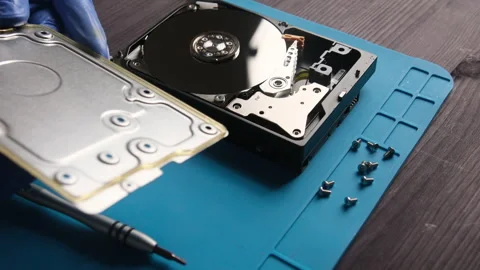 Repairman opens computer hard disk drive to fix in service center Stock Footage 323963668