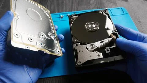Repairman opens computer hard disk drive to fix in service center Stock-Fotos