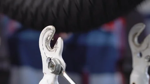 A repairman performs bicycle maintenance. A guy in a shirt mounts the front Stock Footage 115277092
