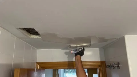 Repairman plastering a water damaged ceiling with a putty knife Видео 341362895