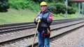 Repairman with shovel in hands stands on railway line HD Footage