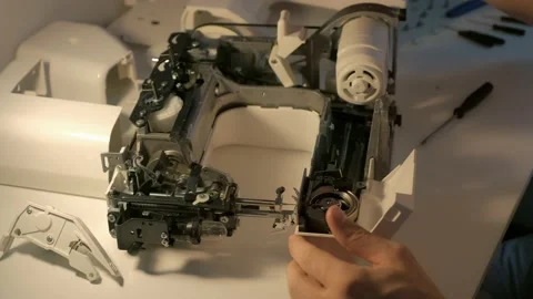 Repairman testing disassembles sewing machine in workshop repairing it. Stock Footage 137693987
