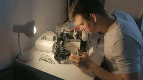 Repairman testing disassembles sewing machine in workshop repairing it. Stock Footage 152962003