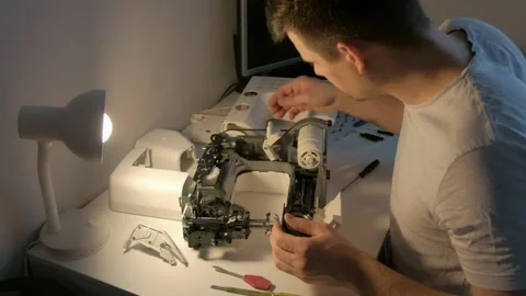 Repairman testing disassembles sewing machine in workshop repairing it. Video stock 153085629