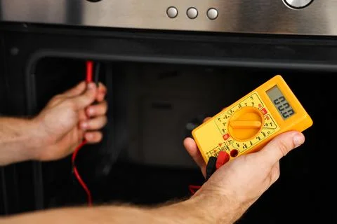 Repairman testing oven element with multimeter, closeup Stock Photos