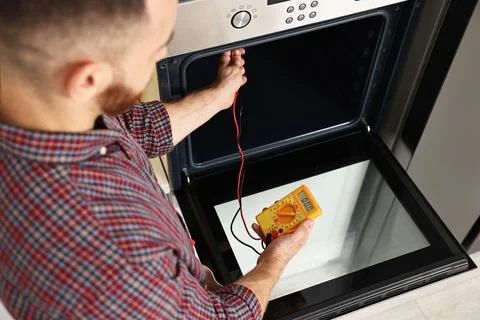 Repairman testing oven element with multimeter, closeup Stock Photos