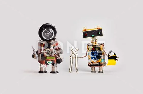 Repairman toy robots with screwdrivers tongs pliers tube of glue. Friendly Stock Photos