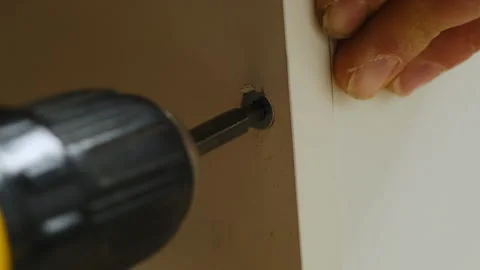 Repairman uses screwdriver to secure panel of cabinet with screw Stock Footage 304402843