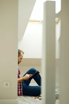 Repairman using digital tablet while sitting on the floor and taking a break Stock Photos