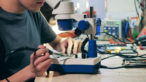 Repairman is using a microscope while fixing a circuit Stock Footage 149678286