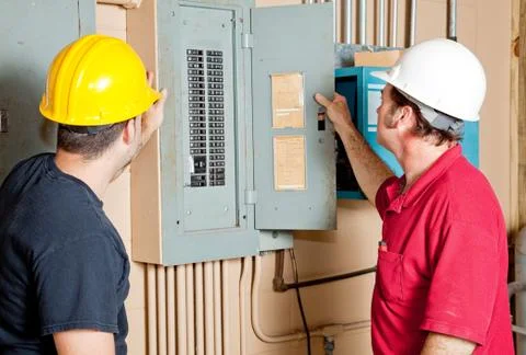 Repairmen Examine Electrical Panel Stock Photos