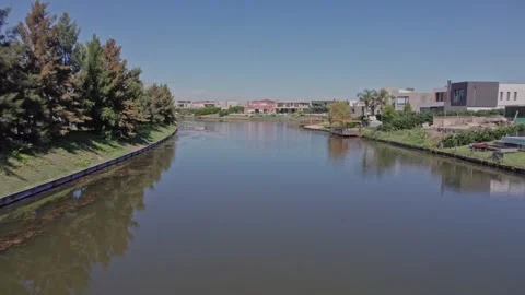 Repeat: Water-Skimming Drone Flight – Nordelta Canals, Buenos Aires Stock Footage 306964618