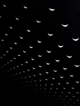 Repeated crescent light pattern on black background Stock Photos