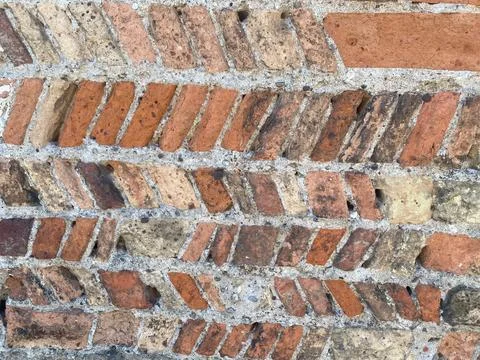 Repeating diagonal brick pattern constructing an ancient wall in Rivolta d'.. Foto stock