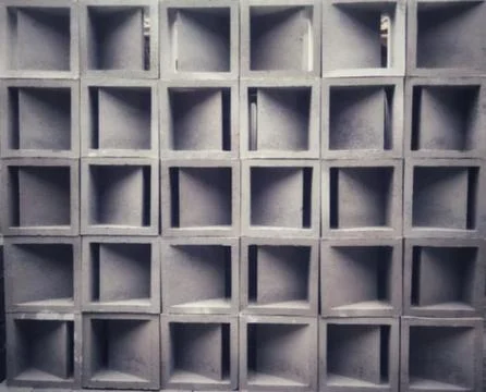 Repeating geometric grid pattern of grey concrete breeze blocks for modern .. Stock Photos