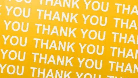 Repeating pattern of the phrase thank you printed in white text on a bright.. Stock Photos