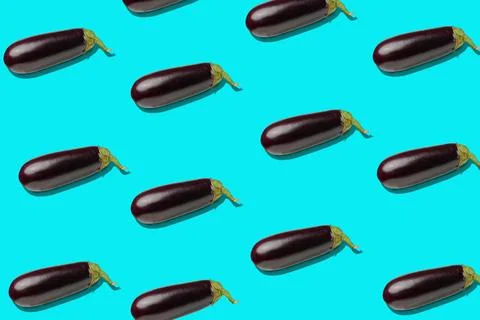 A repeating pattern of shiny eggplants arranged in diagonal rows on a turqu.. Stock Photos