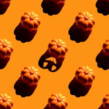 Repeating pumpkins pattern on orange background. Stock Photos