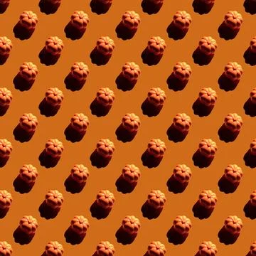 Repeating pumpkins pattern on orange background. Stock Photos