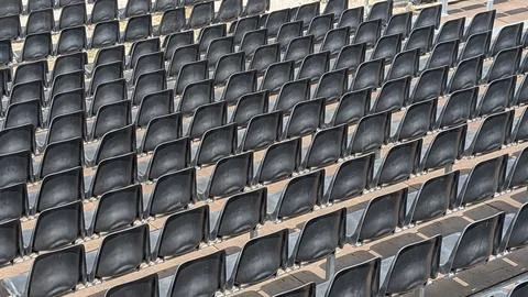 Repeating rows of empty black stadium seats Stock Photos