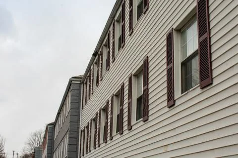 Repeating Windows With Brown Shutters on a White Apartment Building Stock Photos